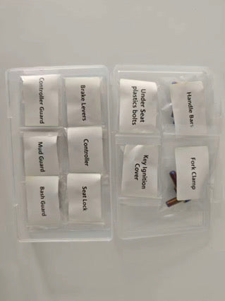 Titanium bolt kit sorted into labelled bags by bike section — controller guard, brake levers, mud guard, bash guard, seat lock, handlebars, fork clamp and more